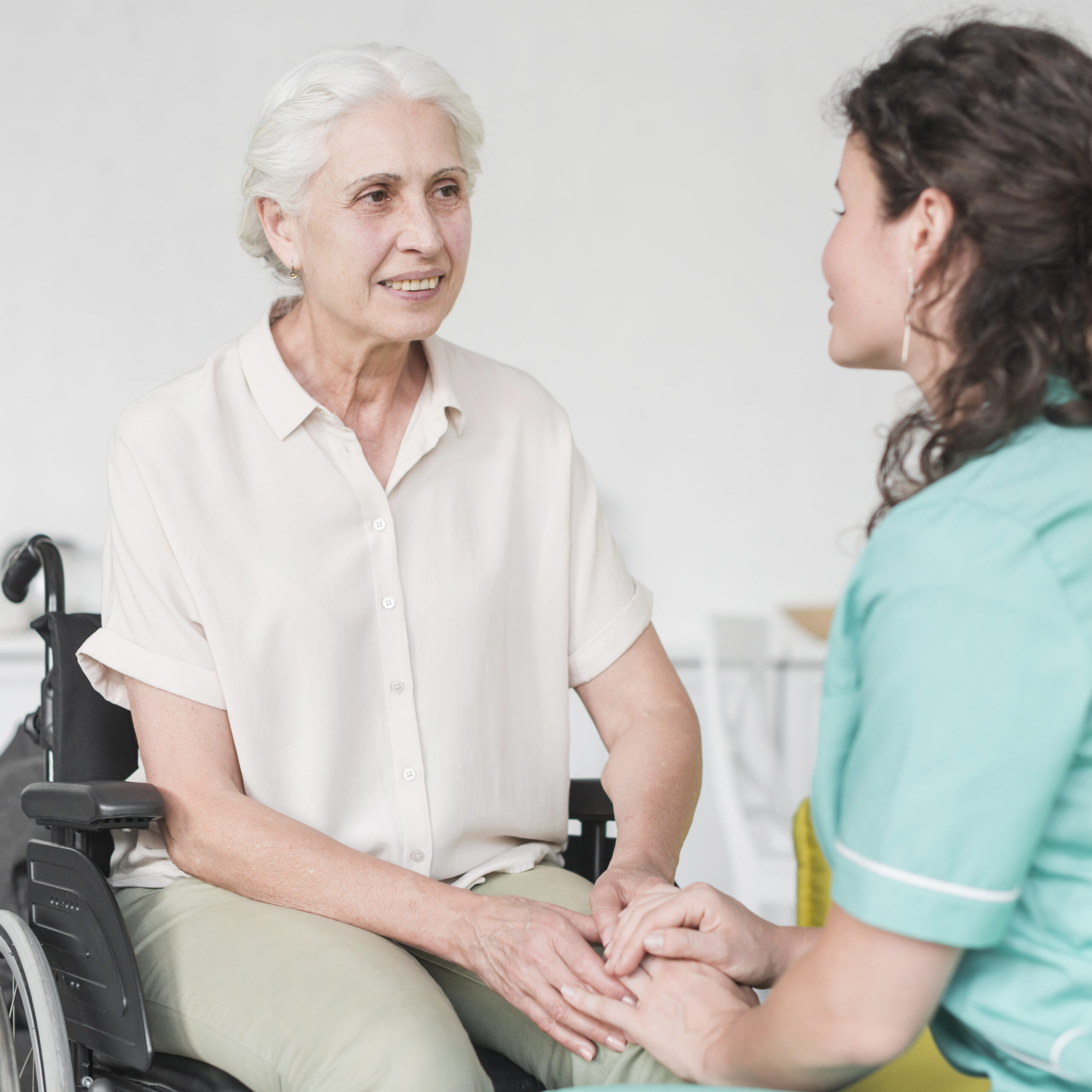 happy-disabled-nurse-sitting-wheel-chair-looking-caretaker